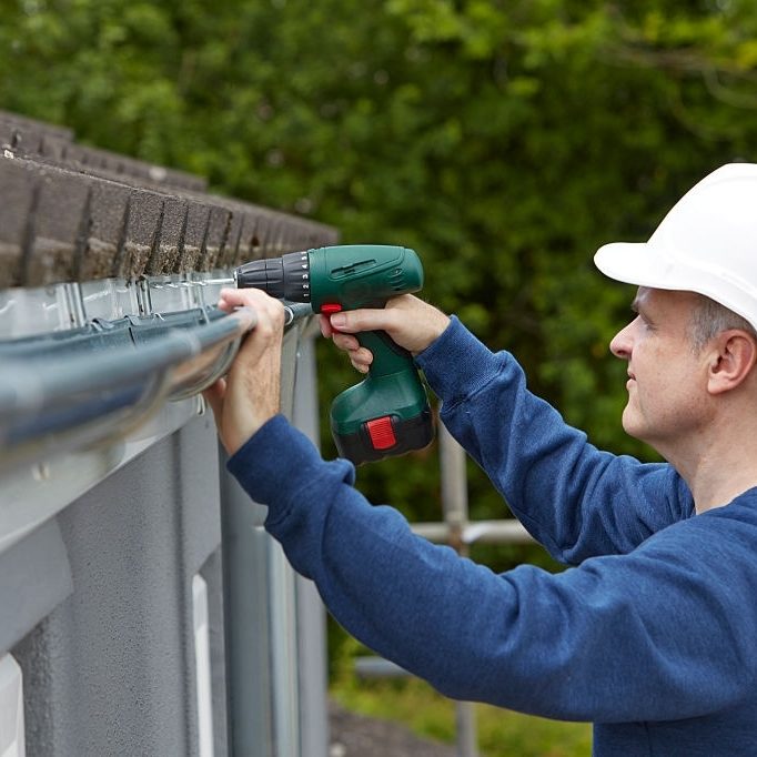 worker fixing the gutter